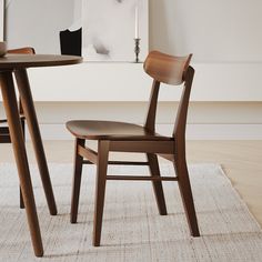 two wooden chairs sitting next to each other on top of a white carpeted floor