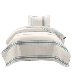 a white bed with blue and green striped comforter set on top of the bed