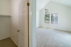 an empty room with white walls and carpet