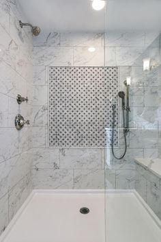 a bathroom with white marble walls and flooring, including a walk - in shower