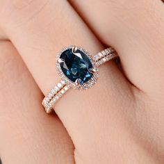 a woman's hand with a ring on it and a blue stone in the middle