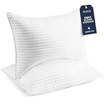 two white pillows sitting next to each other on top of a pillow case with a tag