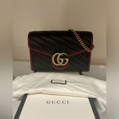 Vintage Effect Calfskin Matelasse Diagonal Torchon Gg Marmont Chain Wallet Black Romantic Cherry This Is An Authentic Gucci Vintage Effect Calfskin Matelasse Torchon Gg Marmont Chain Wallet In Red And Black. The Bag Features An Optional Aged Gold Chain-Link Shoulder Strap And A Prominent Textured Gold Interlocking Gg Logo On The Crossover Flap. The Bag Snaps Open To A Partitioned Black Fabric Interior With A Zipper Compartment, Patch Pockets, And Card Slots. Base Length: 8 In Height: 5.5 In Widt Black Gucci Bags With Branded Hardware, Gucci Black Bag As Gift, Gucci Leather Shoulder Bag Perfect For Gifts, Gucci Leather Bags For Gift, Black Gucci Bag As Gift, Black Designer Gucci Bag, Gucci Black Everyday Luxury Bags, High-end Black Gucci Shoulder Bag, Black Gucci Bag For Everyday Luxury