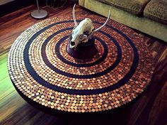 a cow skull sitting on top of a round table covered in pennets and coins