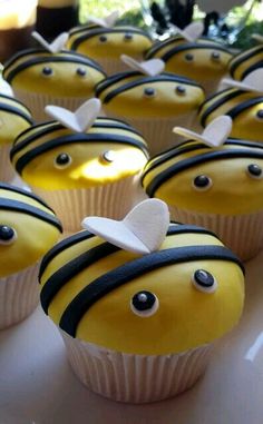 some cupcakes with yellow frosting and black stripes on them are decorated like a bee