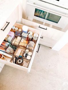 an open drawer in the middle of a kitchen counter with various items inside and out