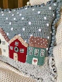 a crocheted pillow with houses on it