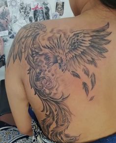 the back of a woman's shoulder with an eagle tattoo on her left arm