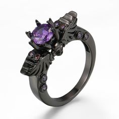 Violet Claw-Set Gothic Skull and Wings Ring Unique Design Embrace the edgy allure of the Violet Claw-Set Gothic Skull and Wings Ring. This gothic-inspired piece features a striking skull and wings design that is sure to turn heads. Stunning Gemstone At the center of this captivating ring lies a rich violet brilliant-cut gem, securely set in an intricate claw setting. The purple gem adds a touch of elegance and sophistication to the punk vibe. Quality Materials Item Type: Fashion Rings Metal Type Witchy Ring, Witch Ring, Skull Wings, Skeleton Ring, Goth Ring, Gothic Engagement Ring, Neo Gothic, Dark Jewelry, Gothic Ring