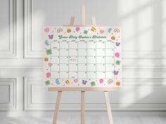 an easel with a calendar on it in front of a white wall and floor