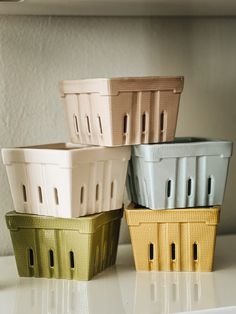 four plastic baskets sitting on top of a white counter