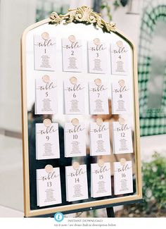 a table plan is displayed in front of a mirror with gold trimmings and white cards