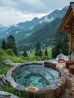 an outdoor hot tub in the middle of mountains