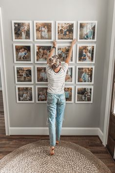 a woman standing in front of a wall with pictures on it