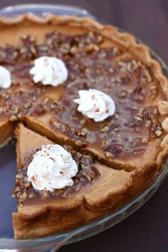 a chocolate pie with pecans and whipped cream on top is ready to be eaten