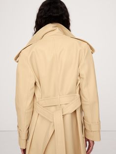 We reimagined the timeless trench coat in a beautiful and soft leather quality known as plongé, prized for its supple, lambskin-like feel.  Here, we made sure to keep the utilitarian vibe of the original through details like a wide lapels, a belted waist, and shoulder epaulettes.  Relaxed fit.  Wide notch lapel.  Belted waist.  Two exterior pockets, one interior pocket.  Center back vent.  Fully lined.  Relaxed fit.  Long sleeves.  Midi length.  Model: Size S, 5'10" (178cm). Luxury Cream Outerwear With Double Button Closure, Beige Leather Outerwear With Lapel Collar, Soft Leather Outerwear For Winter Workwear, Soft Leather Winter Outerwear For Work, Soft Leather Outerwear For Winter Professional Wear, Elegant Cream Leather Outerwear, Modern Beige Leather Outerwear, Cream Leather Outerwear For Work, Elegant Leather Pea Coat For Work