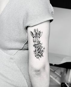 a giraffe and flowers tattoo on the left upper half of the right arm