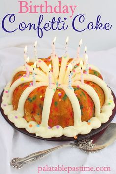 a birthday cake with white frosting and sprinkles is on a plate