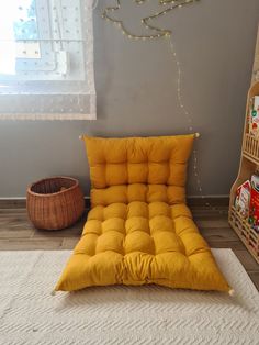 a yellow futon bed sitting on top of a white rug next to a book shelf