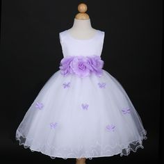 a white dress with purple flowers and butterflies on the skirt is displayed in front of a mannequin