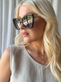 a blonde woman wearing sunglasses looking off into the distance