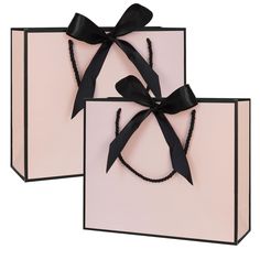 two pink gift bags with black bows on them