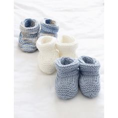 several crocheted baby booties sitting on top of a bed