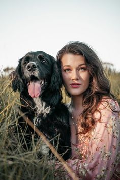 a woman and her dog are posing for a photo in the tall grass with their tongues out