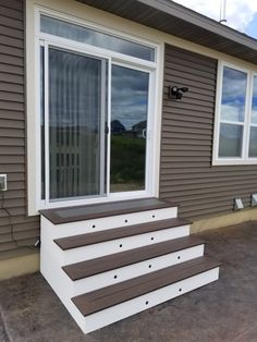 a house that has some steps in front of the door and windows on the side