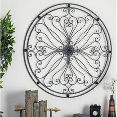 a large metal clock mounted to the side of a wall next to a book shelf