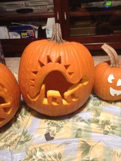 three carved pumpkins sitting on top of a table