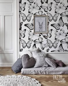 a bedroom with butterflies on the wall next to a bed and rugs in front of it