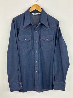 Amazing deadstock condition. Tag XL Denim Blue Long Sleeve Shirt For Rodeo, Long Sleeve Denim Blue Shirt For Rodeo, Dark Wash Long Sleeve Shirt For Rodeo, Denim Blue Button-up Shirt For Rodeo, Medium Wash Shirt With Button Closure For Rodeo, Western Style Medium Wash Shirt With Pockets, Western Style Denim Blue Shirt For Rodeo, Long Sleeve Denim Shirt For Rodeo, Classic Dark Wash Shirt For Rodeo