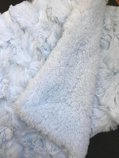 a pile of fluffy white blankets sitting on top of a wooden floor