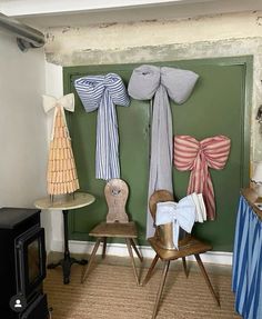 a room with two chairs and several different bows on the wall above them, along with other decorations