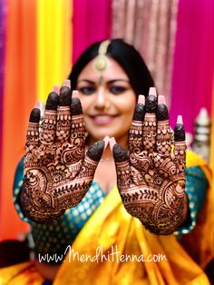 a woman holding up her hands with henna on it