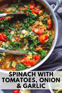 spinach with tomatoes onion and garlic in a large pot on a blue towel next to other dishes