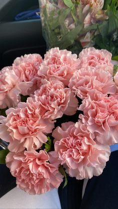 pink carnations are in a vase on the table