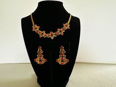 "Vintage red rhinestone necklace and earring set by Garne.  This Art Nouveau/Edwardian style matching set is a high quality example of collectible costume jewelry.  From the 50s, the necklace/choker measures approximately 15 1/2\".  The earrings are approx. 1 1/4\" in length and are screw back.  It has all it's rhinestones, which are a rich ruby/cranberry red, and are prong set.  Made of a smooth, shiney gold tone metal, which has never tarnished.  It is unmarked, but has the hallmark of Garne.  In excellent vintage condition.  I do not have the original box.  A fun and elegant Christmas or Holiday jewelry set, or unique Christmas gift for a friend.  Thanks for looking! FREE SHIPPING in US INTERNATIONAL SHIPPING - if shipping costs are less than estimated, the difference is refunded." Red Jeweled Jewelry Sets For Party, Traditional Red Jewelry For Evening, Elegant Red Jewelry Sets For Festive Occasions, Red Temple Jewelry Necklaces For Formal Occasions, Red Jeweled Jewelry For Evening, Red Jeweled Jewelry Set For Celebration, Red Evening Jewelry, Festive Red Jeweled Jewelry Sets, Festive Red Necklaces With Matching Earrings