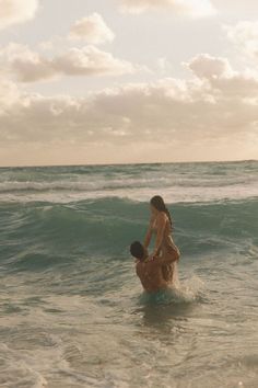 two people in the ocean playing with each other