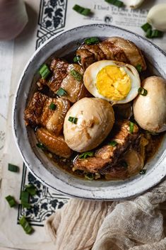 a bowl filled with meat and eggs on top of a table