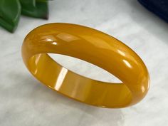 "A vintage chunky Bakelite bangle bracelet in butterscotch yellow. Tested with Simichrome. No marks. Measures about .75\" wide and 8.25\" around on the inside. Some scratches. Actual packaging will vary depending on item/s purchased and tape pattern available. Props/boxes shown in photos are for display purposes only, not included in this listing. As always, satisfaction is guaranteed. Thanks for shopping Vintage In Bloom More Bakelite: http://www.etsy.com/shop/VintageInBloom/search?search_query Vintage Yellow Round Bracelets, Retro Yellow Bangle Bracelets, Retro Yellow Bangle Bracelet, Handmade Vintage Yellow Bracelets, Prop Box, Bakelite Jewelry, Tape Pattern, Bakelite Bangles, In Bloom