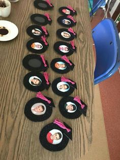 a table topped with lots of black hats covered in pictures and pink ribbon around them