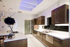 a modern kitchen with wooden cabinets and white counter tops, along with a large center island