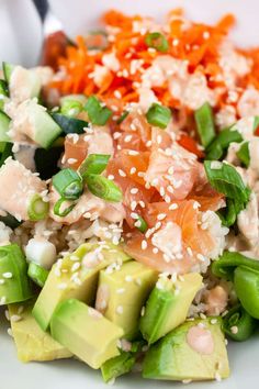 a white plate topped with rice, cucumber and salmon