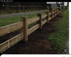 a wooden fence along the side of a road