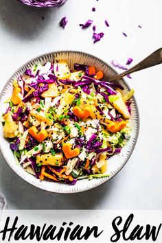 a bowl filled with coleslaw and carrots on top of a white table