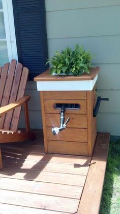 a wooden chair sitting on top of a wooden deck next to a potted plant