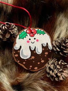 a christmas ornament is hanging on a furry surface with pine cones and other decorations