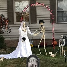 two skeletons dressed up in wedding attire holding hands with a bride and groom standing next to each other